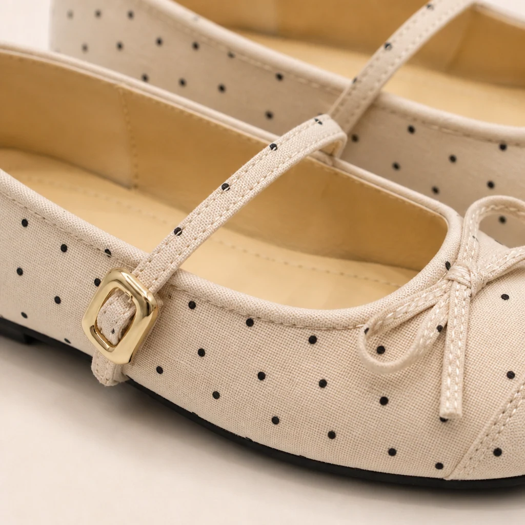 Gros plan sur le nœud, la bride et la texture satinée des chaussures plates Mary Jane