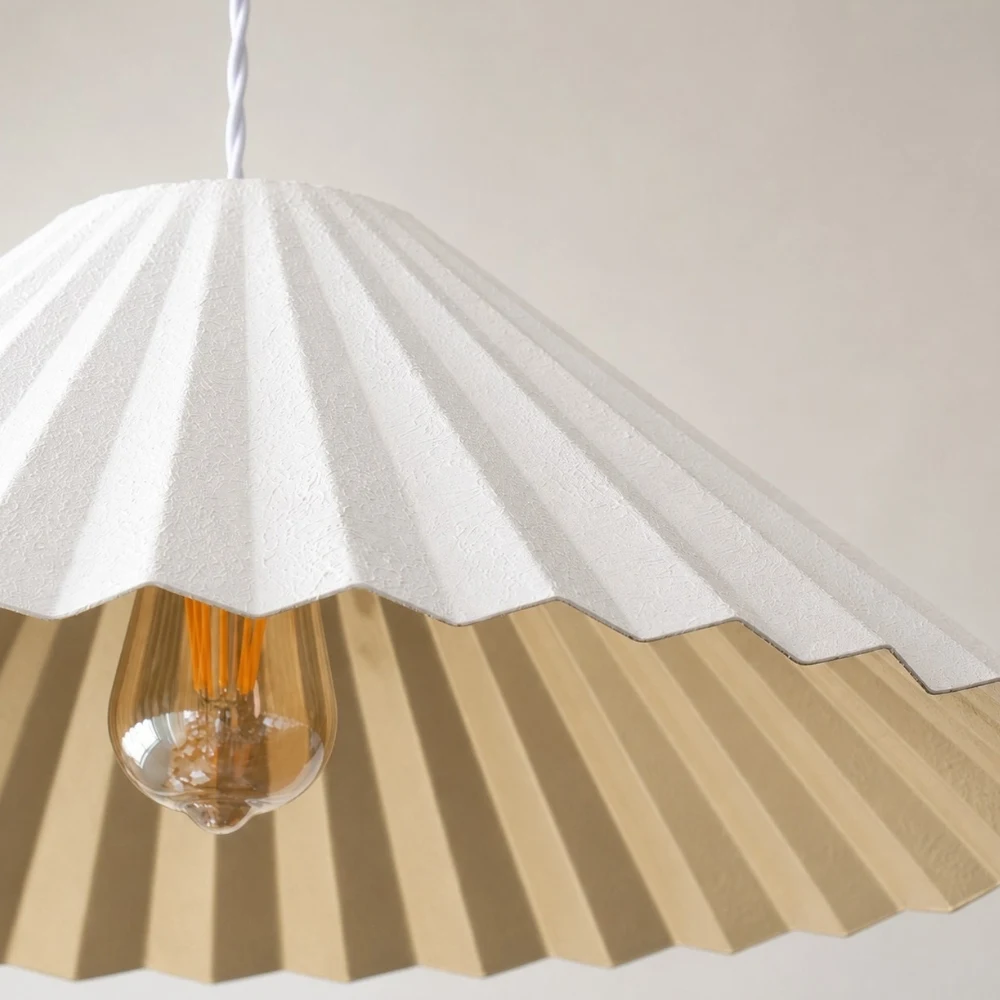 White pleated metal shade detail with gold interior