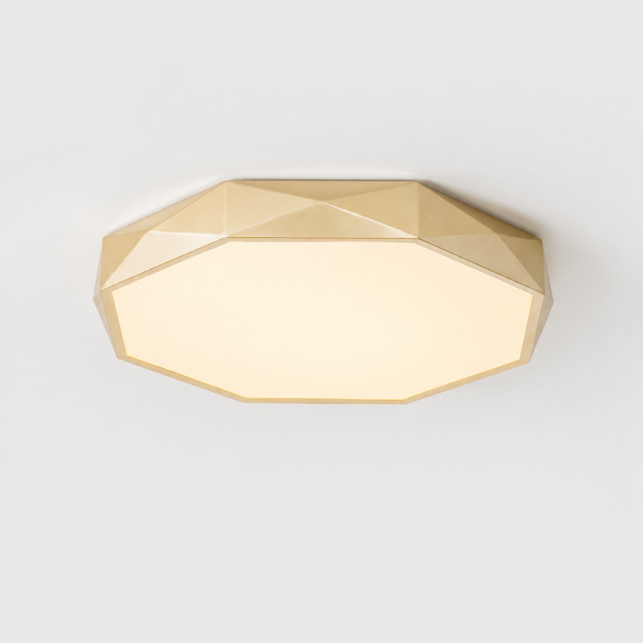 Gold ceiling light with softly illuminated warm diffuser